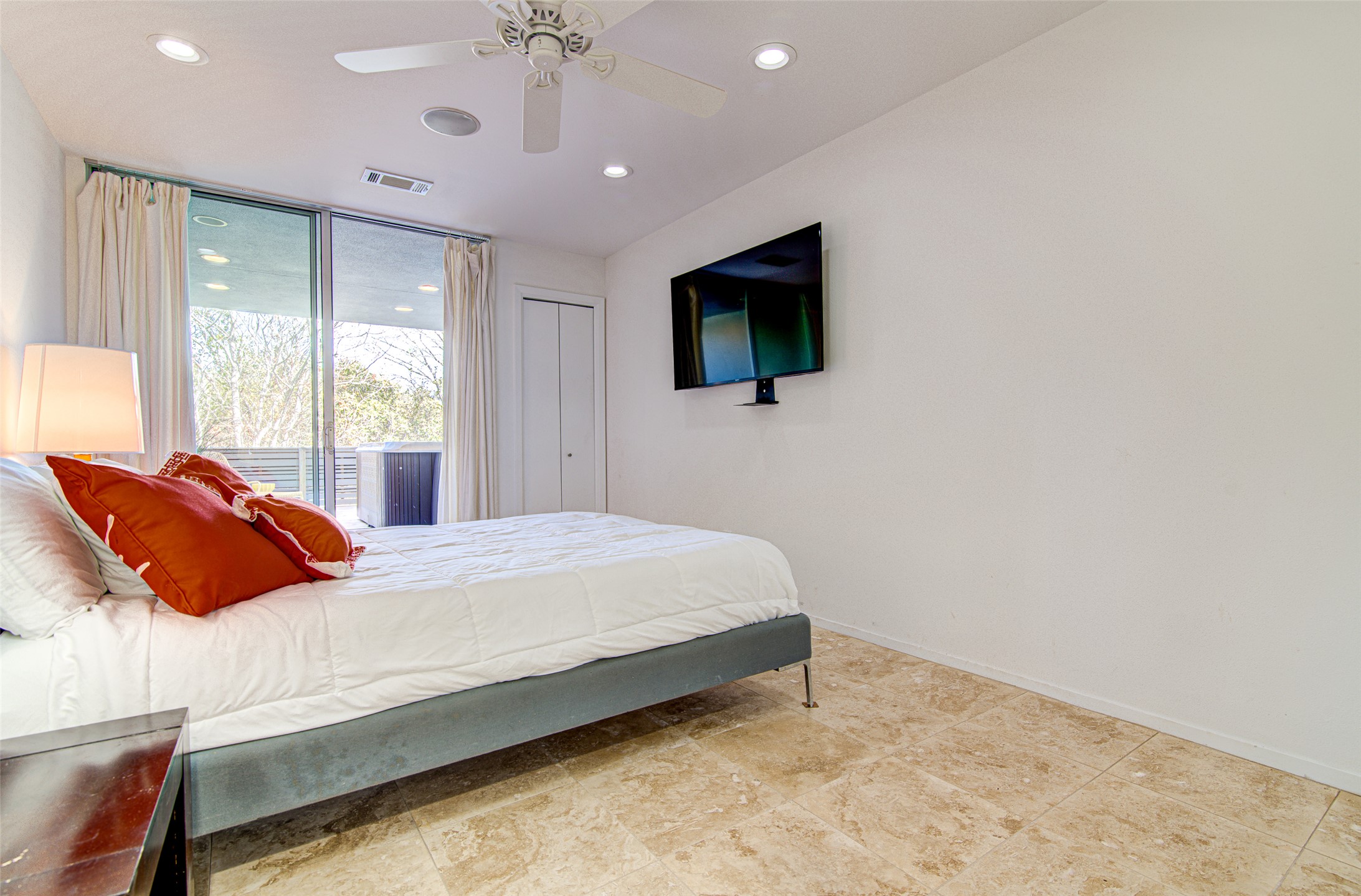 9707 Timber Ridge Pass Austin, TX 78733 - Photo 17 of 18 Sliding glass doors open from the tiled bedroom to a private patio space.