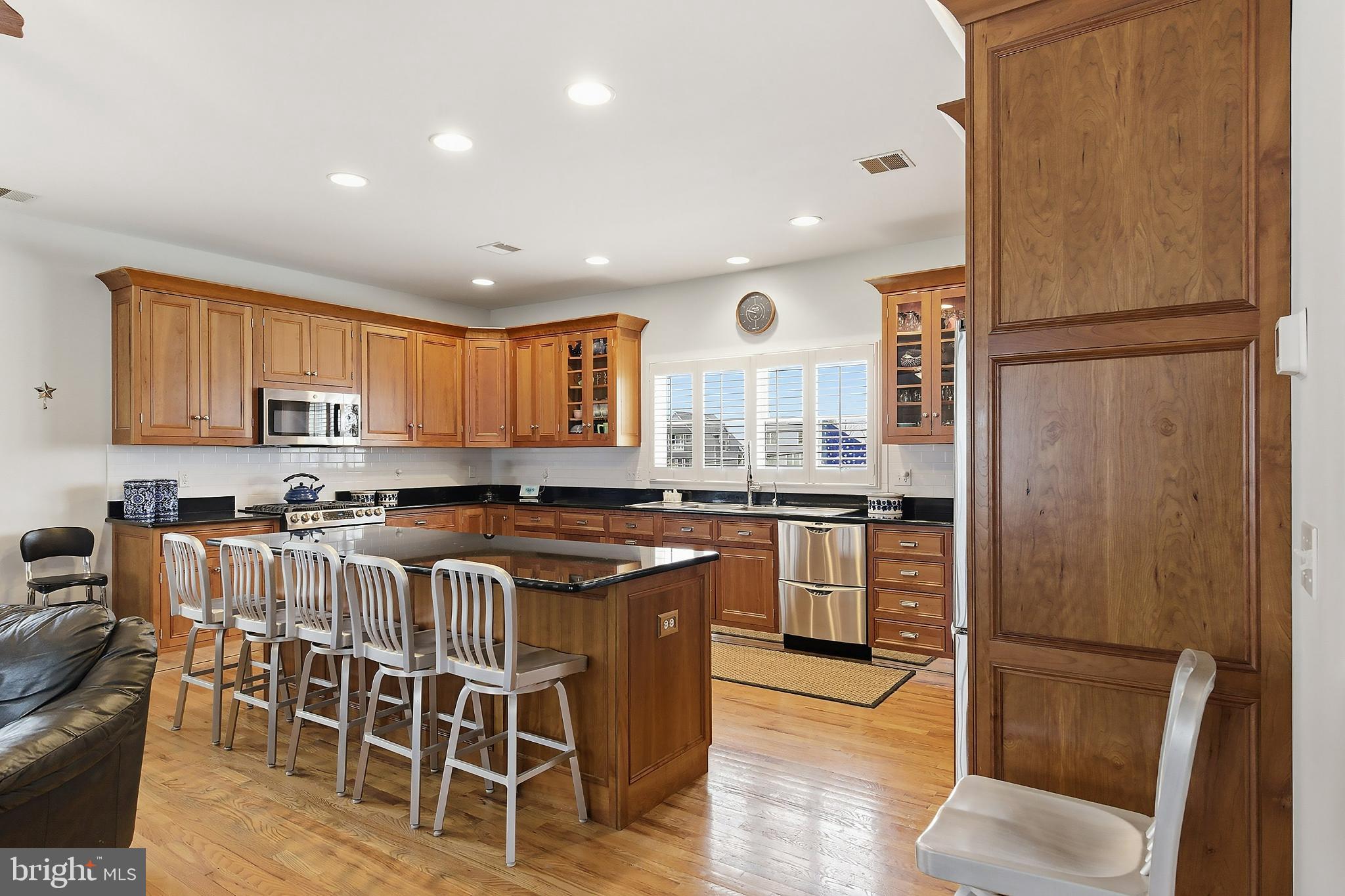 33 Sands Point Road Waretown, NJ 08758 - Photo 23 of 79 a kitchen with stainless steel appliances granite countertop a stove a refrigerator a sink a dining table and chairs with wooden floor