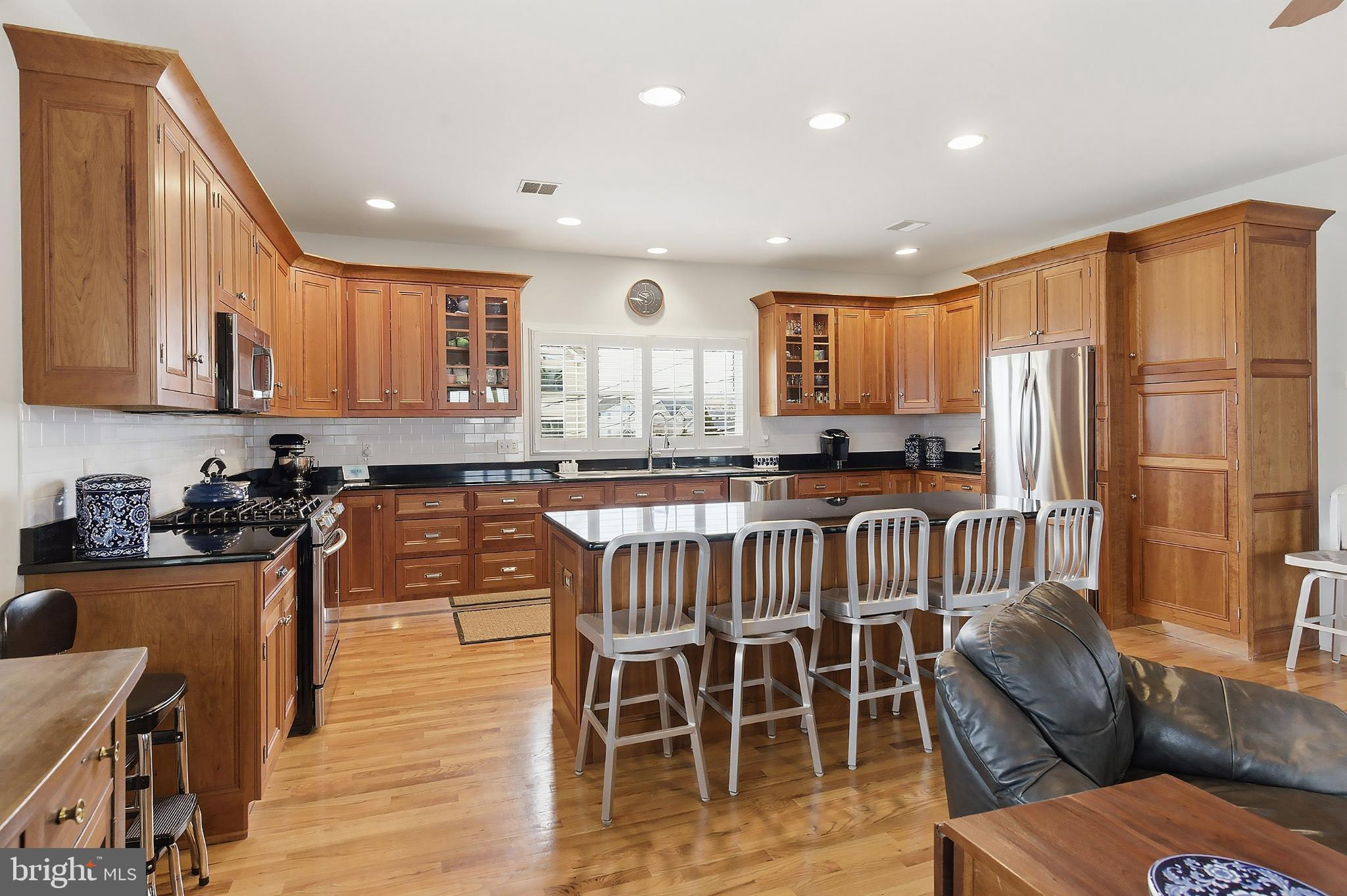33 Sands Point Road Waretown, NJ 08758 - Photo 24 of 79 a kitchen with stainless steel appliances granite countertop a stove top oven a sink a dining table and chairs with wooden floor