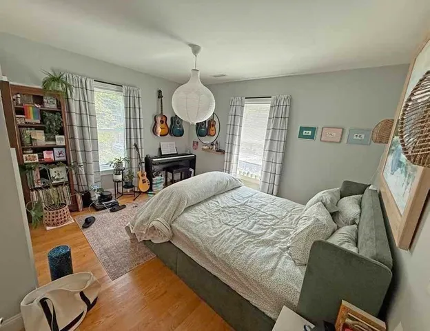 a bedroom with a bed furniture and a flat tv screen