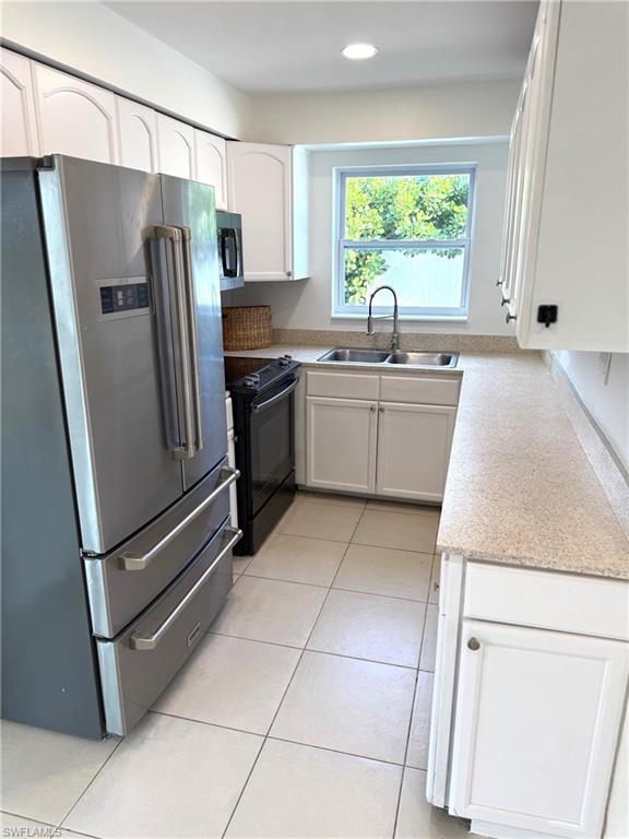 585 14th Street North Naples, FL 34102 - Photo 8 of 24 a kitchen with stainless steel appliances granite countertop a refrigerator sink and microwave