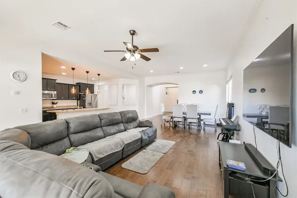 a living room with furniture kitchen view and a chandelier