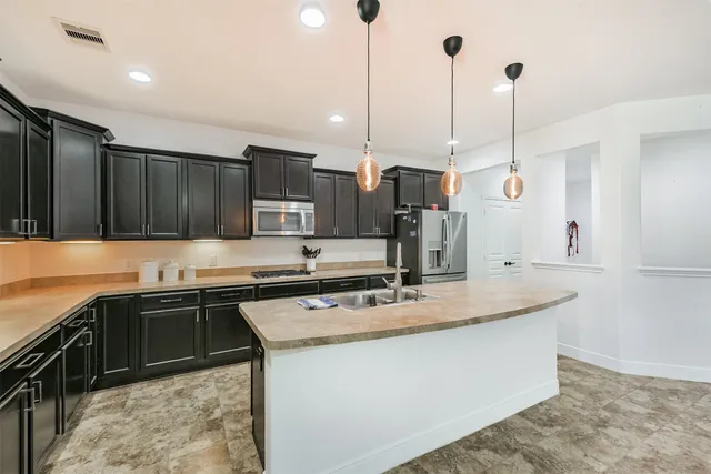 a kitchen with stainless steel appliances granite countertop a sink a stove and a refrigerator