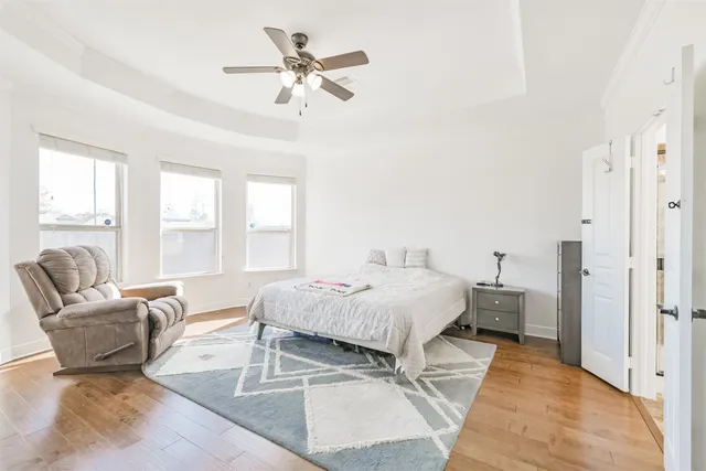 a spacious bedroom with a bed a couch and large windows