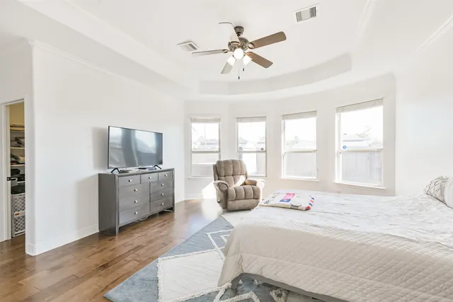 a bedroom with furniture large window and flat screen tv