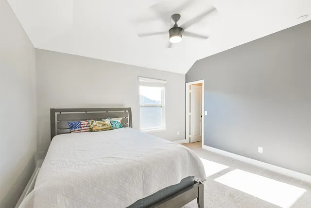 a bedroom with a large bed and a chandelier