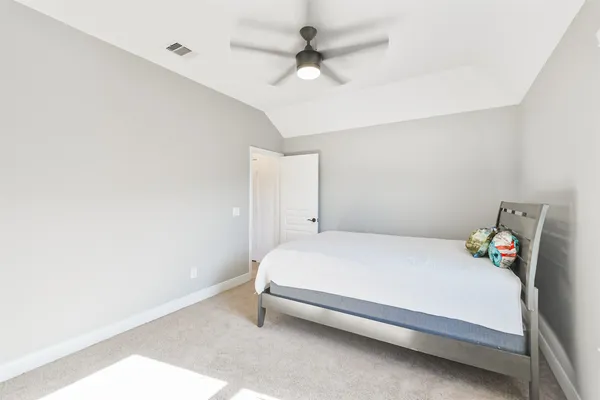 a bedroom with a bed and a ceiling fan