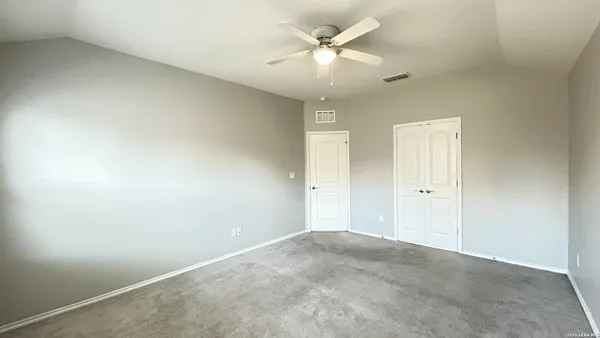 an empty room with chandelier fan