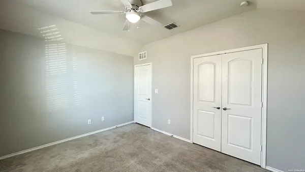 an empty room with a window and a fan