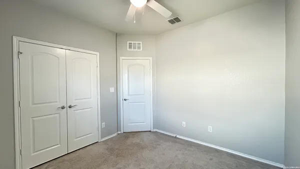 an empty room with a ceiling fan and a window