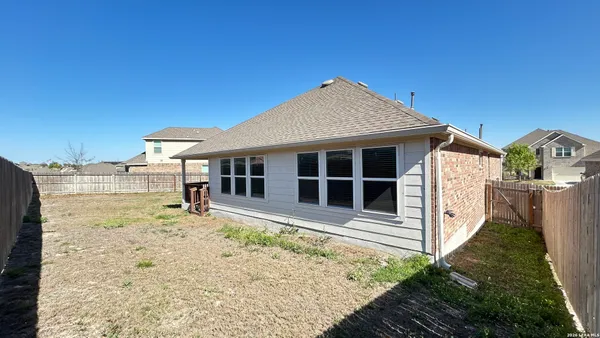 a view of a house with backyard porch and wooden fence