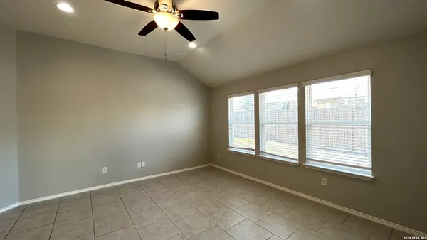 a view of empty room with window and ceiling fan