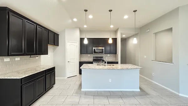 a large kitchen with kitchen island a sink stainless steel appliances and cabinets