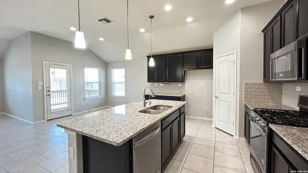 a kitchen with stainless steel appliances granite countertop a sink stove and cabinets