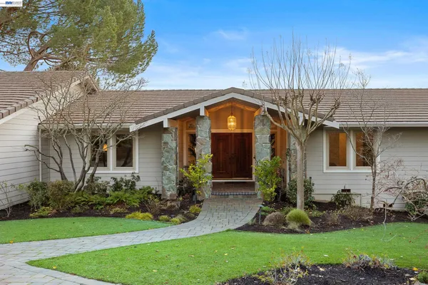 a front view of a house with a garden and plants