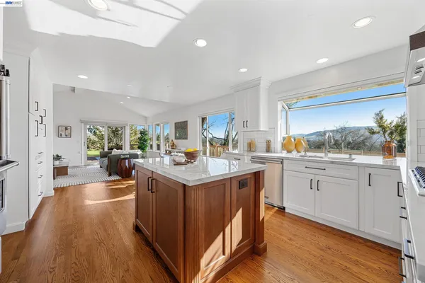 a kitchen with kitchen island a counter top space a sink stainless steel appliances and cabinets
