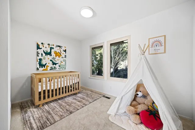 a view of a large garden with lawn chairs under an umbrella
