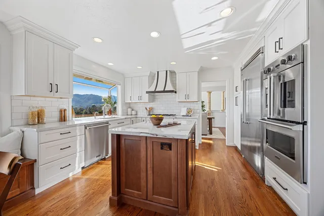a kitchen with stainless steel appliances granite countertop a sink a stove and cabinets