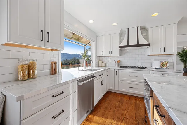 a kitchen with stainless steel appliances kitchen island granite countertop a refrigerator and a stove top oven