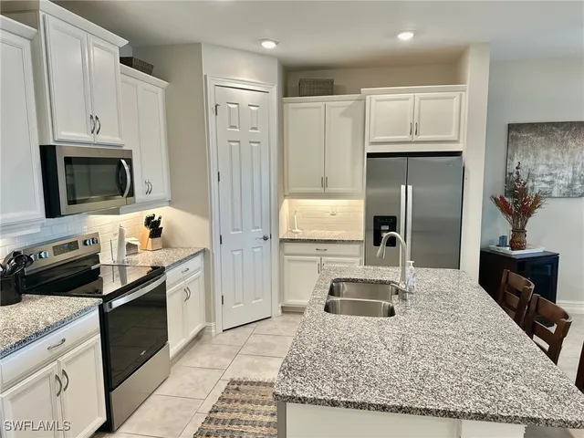 a kitchen with kitchen island granite countertop a sink stove and refrigerator