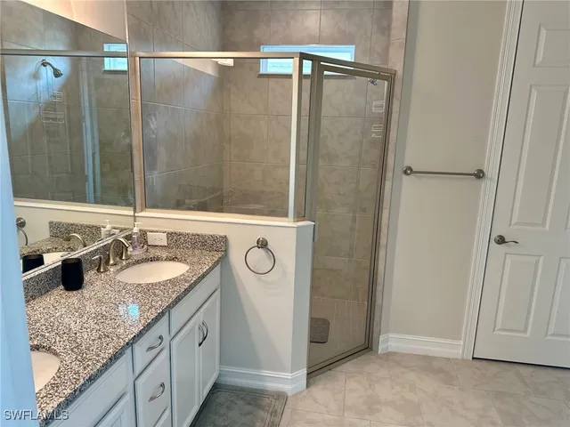 a bathroom with a granite countertop shower sink and mirror