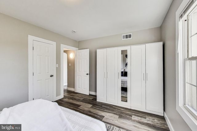 a view of a bedroom with wooden floor and windows