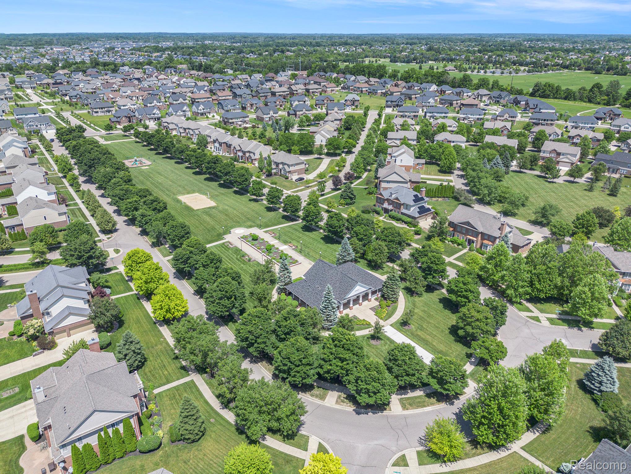 50873 Scarborough Road Canton, MI 48188 - Photo 31 of 33 Expansive residential development featuring mature trees, manicured green spaces, and a community building with a columned entrance