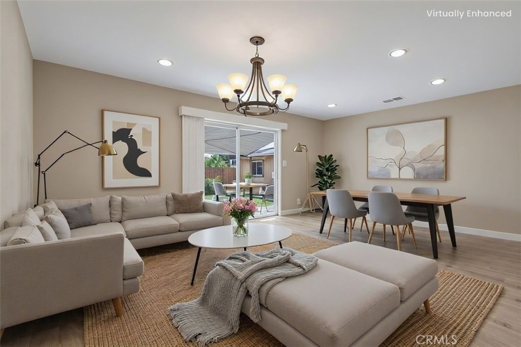 a living room with furniture a chandelier and a dining table