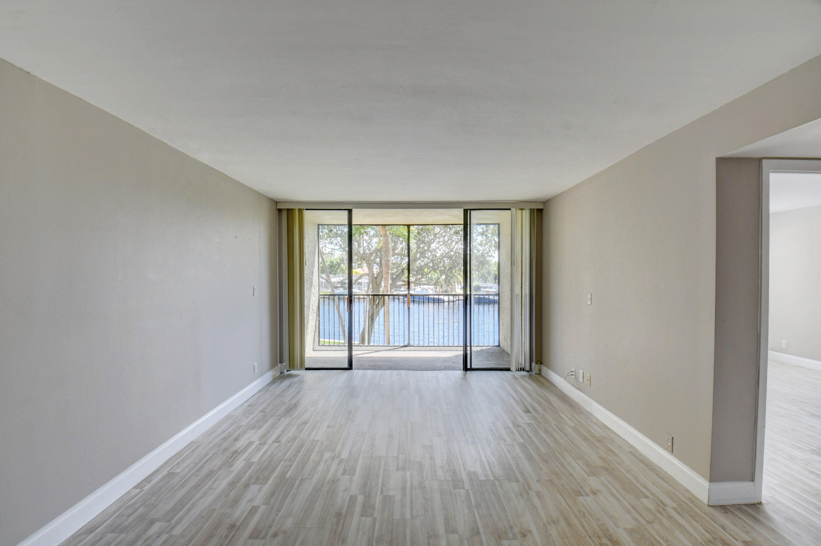 14 Royal Palm Way, Unit 2050 Boca Raton, FL 33432 - Photo 12 of 44 a view of an empty room with wooden floor and a window
