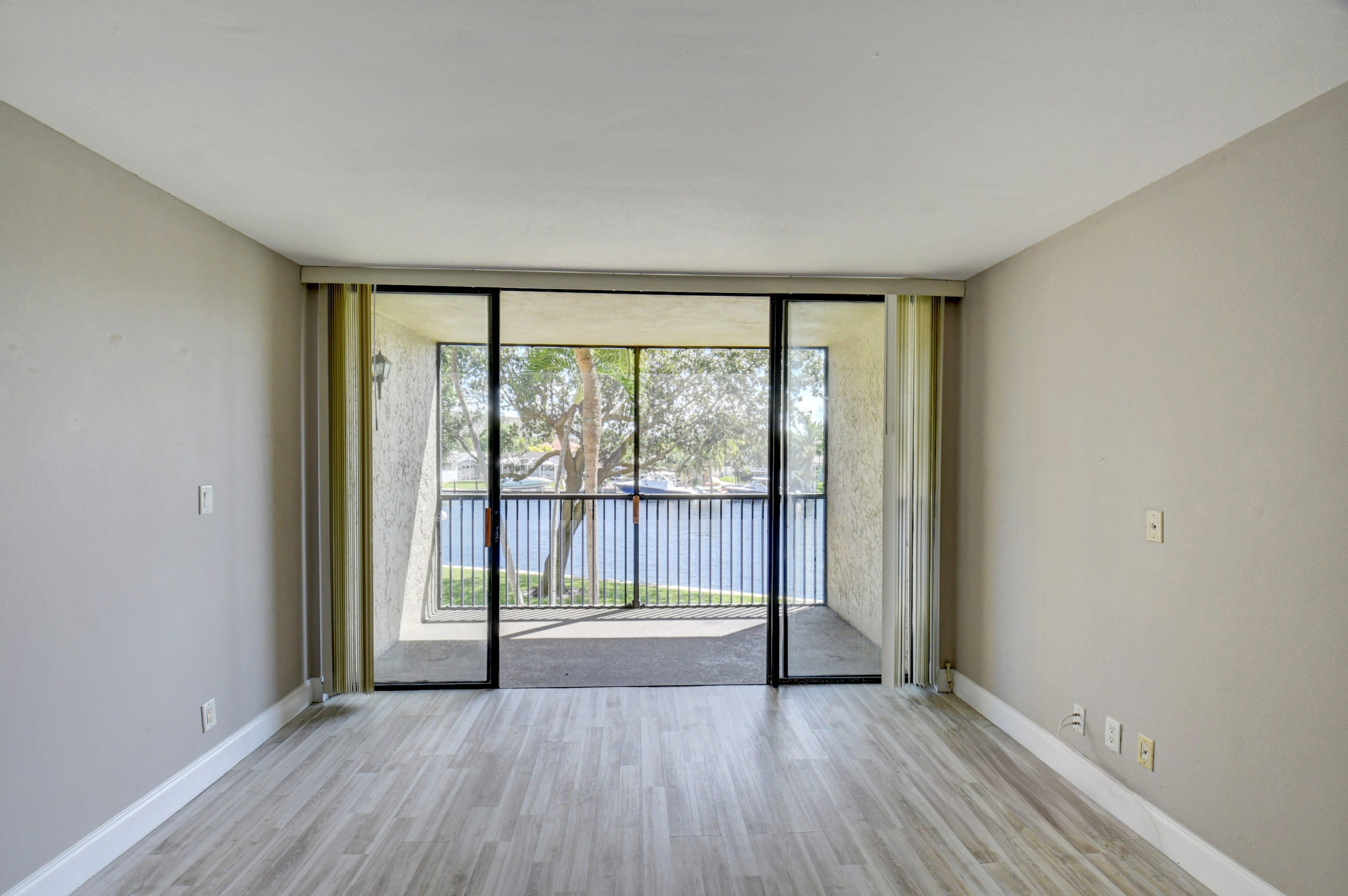 14 Royal Palm Way, Unit 2050 Boca Raton, FL 33432 - Photo 14 of 44 a view of an empty room with wooden floor and a window