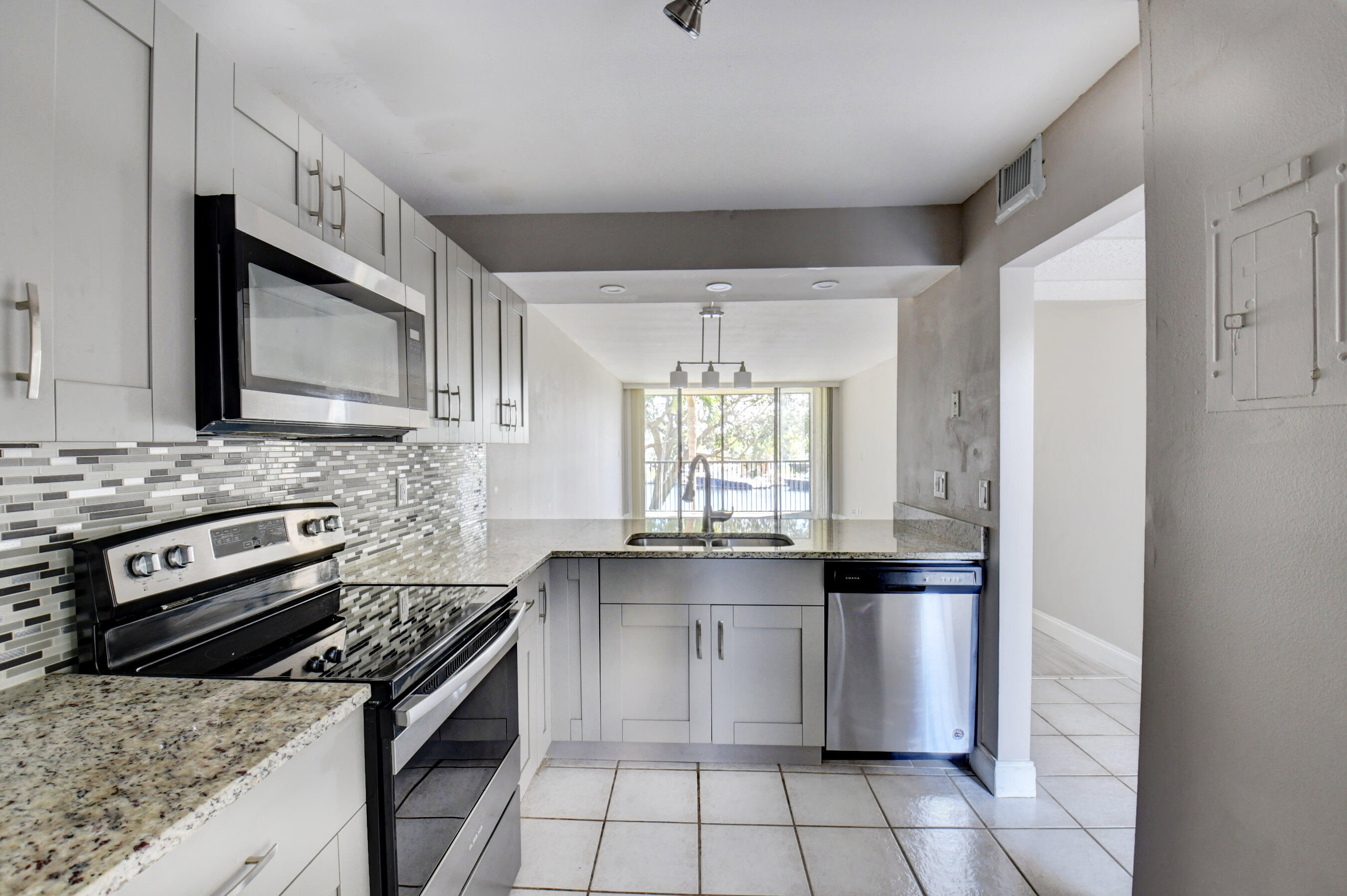 14 Royal Palm Way, Unit 2050 Boca Raton, FL 33432 - Photo 18 of 44 a kitchen with stainless steel appliances granite countertop a stove a sink and a microwave