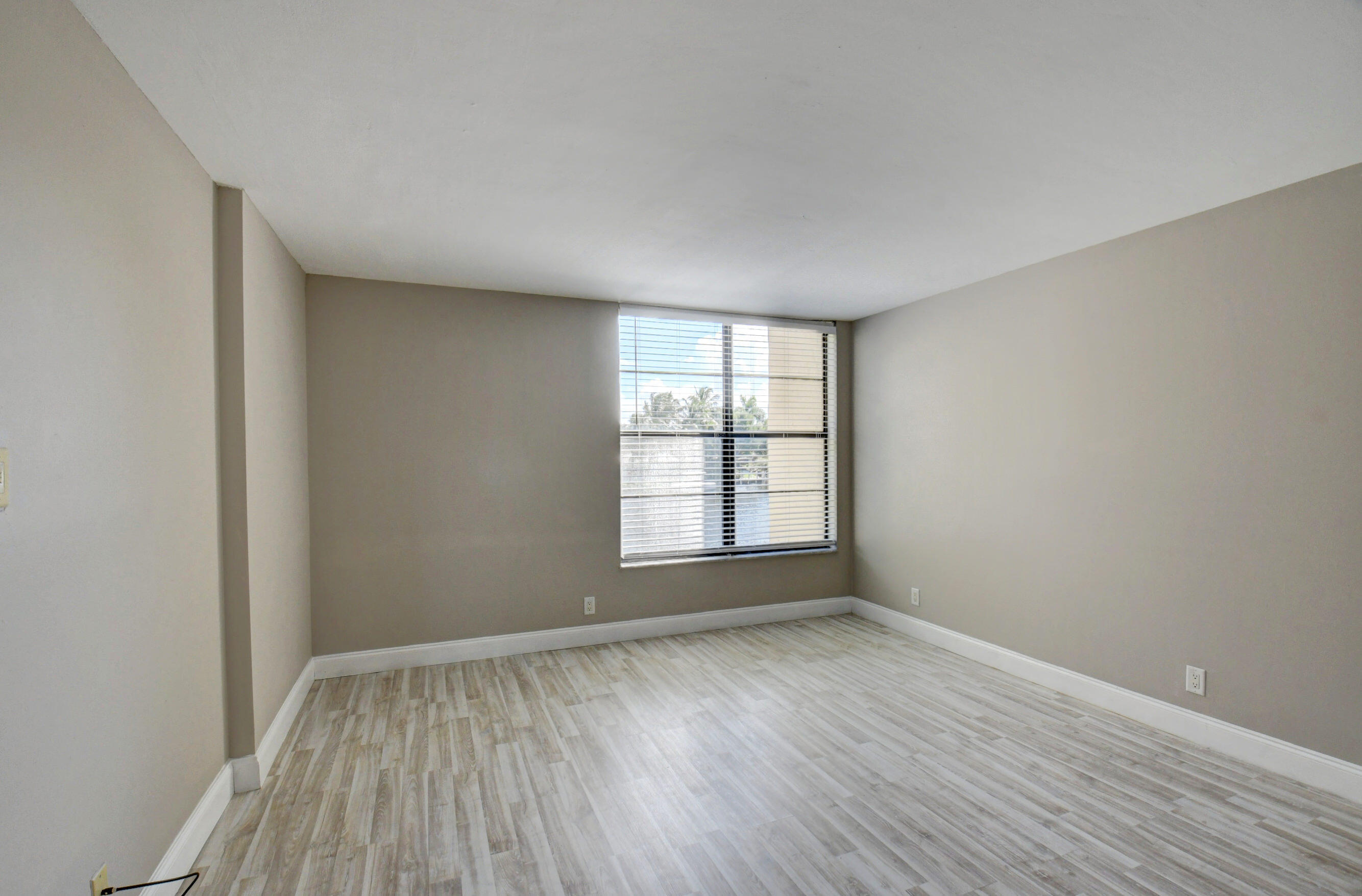 14 Royal Palm Way, Unit 2050 Boca Raton, FL 33432 - Photo 25 of 44 an empty room with wooden floor and windows