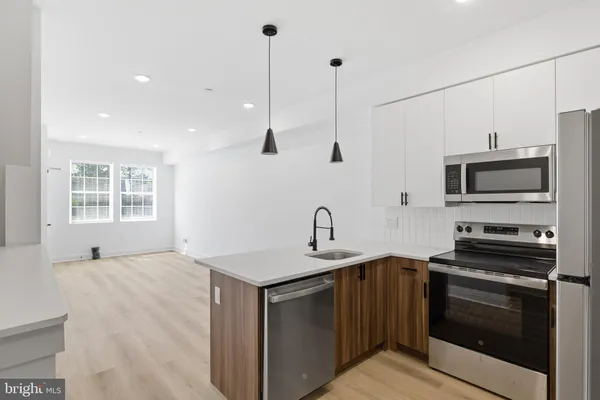 a kitchen with stainless steel appliances a stove sink microwave and cabinets