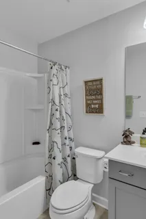 a bathroom with a sink a toilet and shower curtain