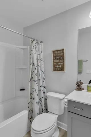 a bathroom with a sink a toilet and shower curtain
