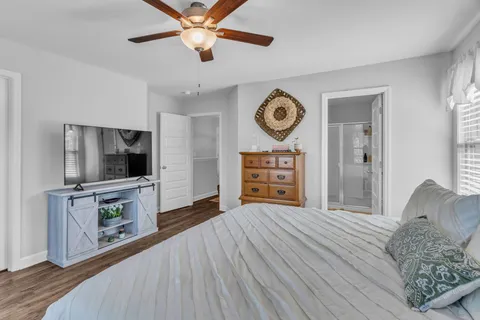 a bedroom with a bed a flat screen tv and a couch