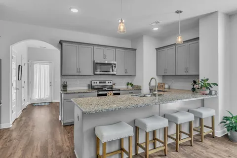 a kitchen with stainless steel appliances granite countertop a sink stove and microwave