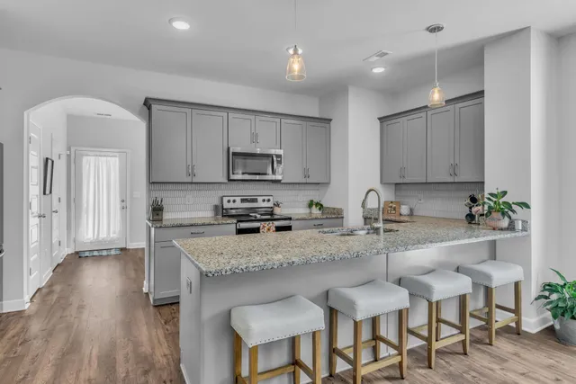 a kitchen with stainless steel appliances granite countertop a sink stove and microwave