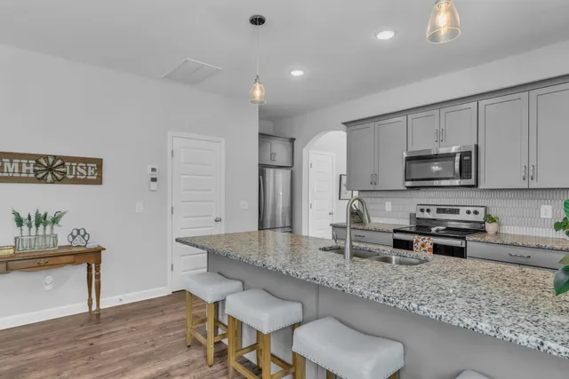 a kitchen with stainless steel appliances granite countertop a sink stove and refrigerator