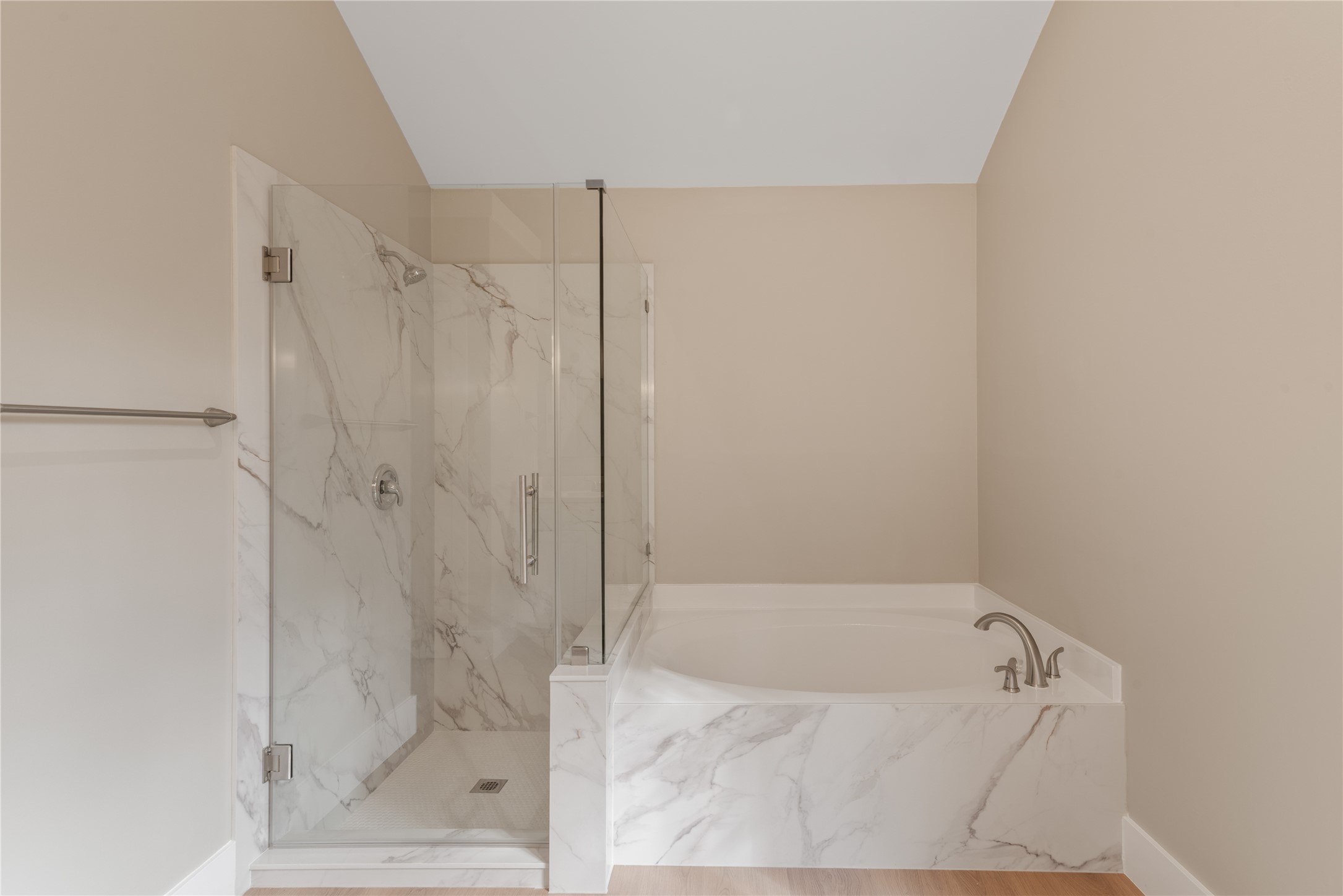 10 White Fawn Drive Spring, TX 77381 - Photo 23 of 25 This bathroom features a modern design with a glass-enclosed shower and a separate bathtub, both accented with elegant marble tiles. The neutral wall color adds to the spacious and serene atmosphere.