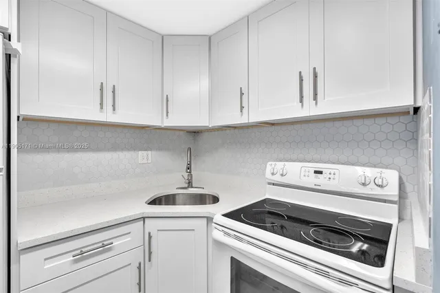 a kitchen with white cabinets and white appliances