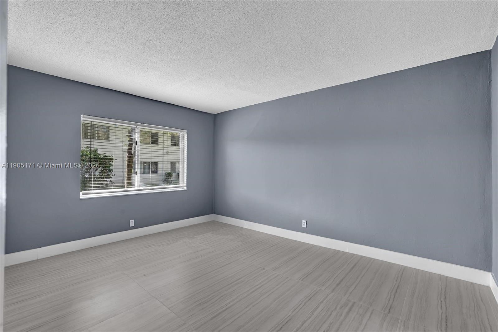 101 Southeast 6th Avenue, Unit 1 Pompano Beach, FL 33060 - Photo 11 of 30 a view of an empty room with wooden floor and a window