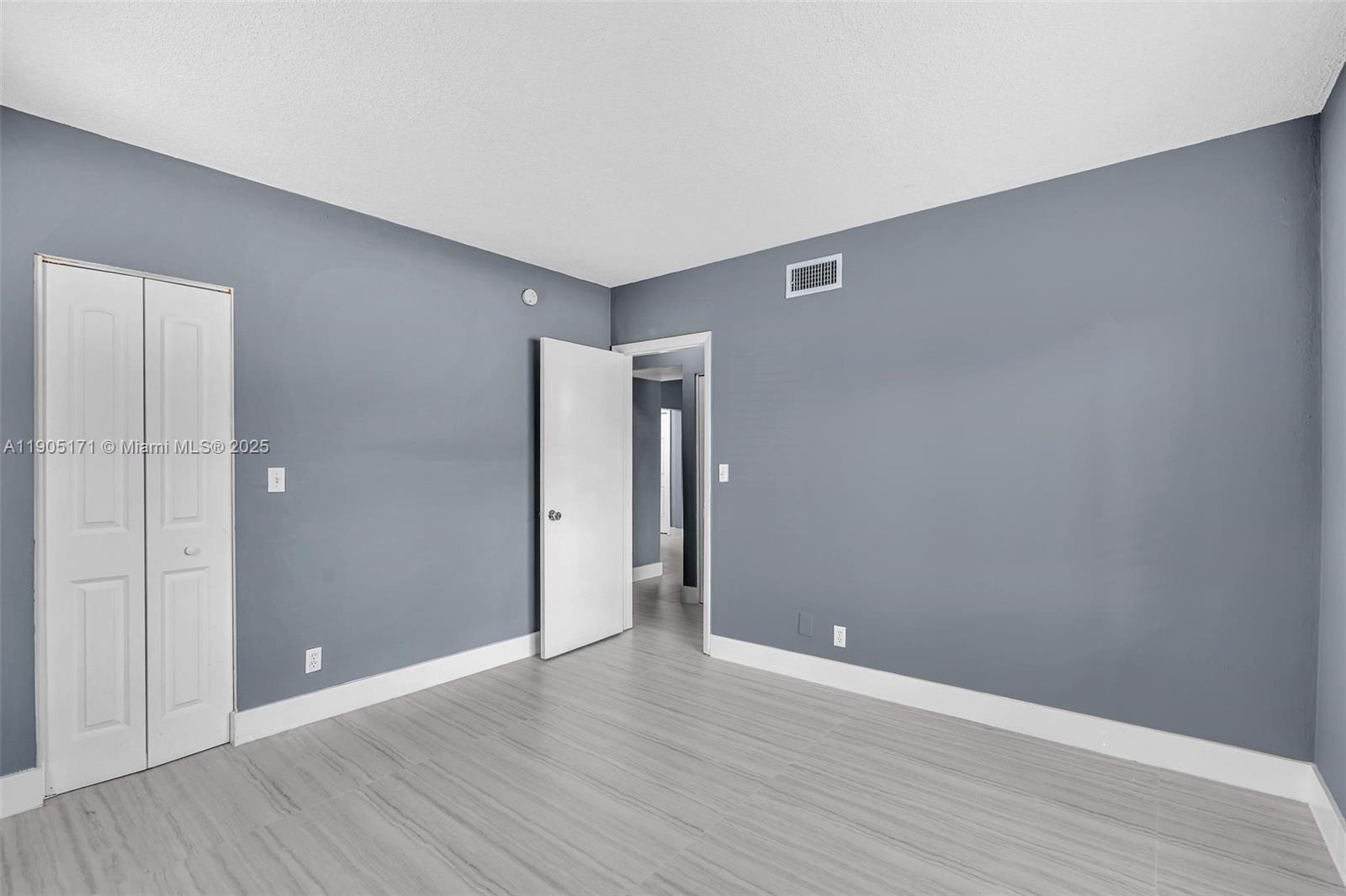 101 Southeast 6th Avenue, Unit 1 Pompano Beach, FL 33060 - Photo 18 of 30 a view of an empty room with wooden floor and closet