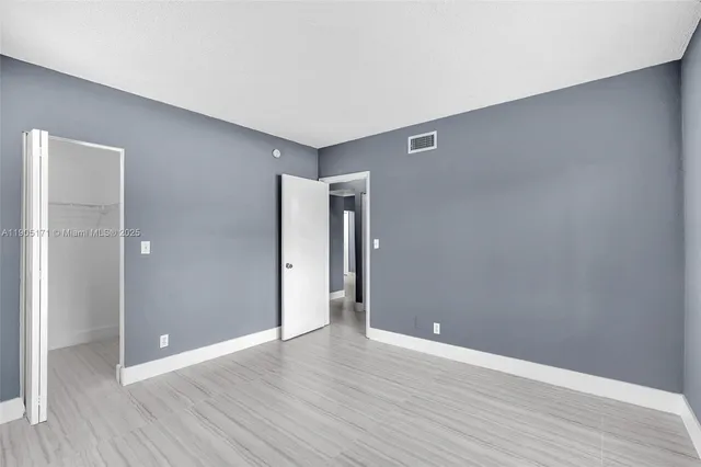 a view of an empty room with wooden floor
