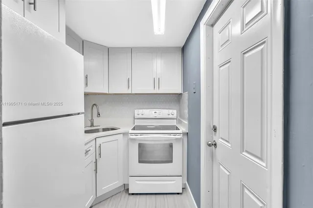 a kitchen with a stove sink and cabinets