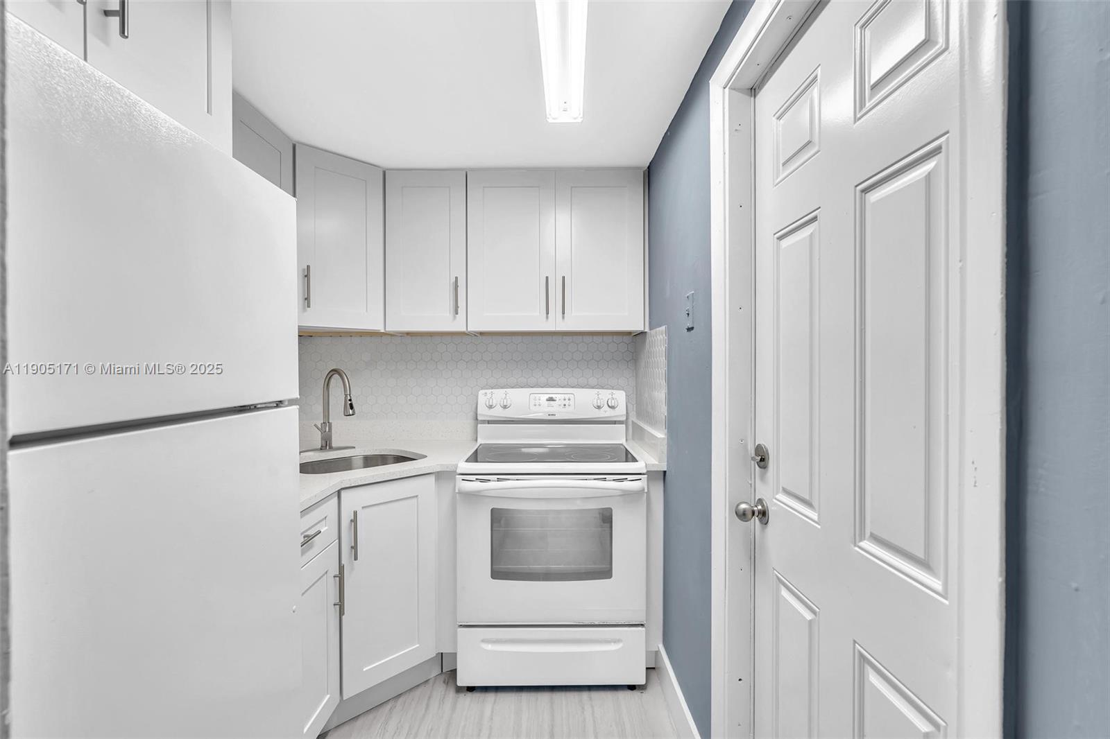 101 Southeast 6th Avenue, Unit 1 Pompano Beach, FL 33060 - Photo 2 of 30 a kitchen with a stove sink and cabinets