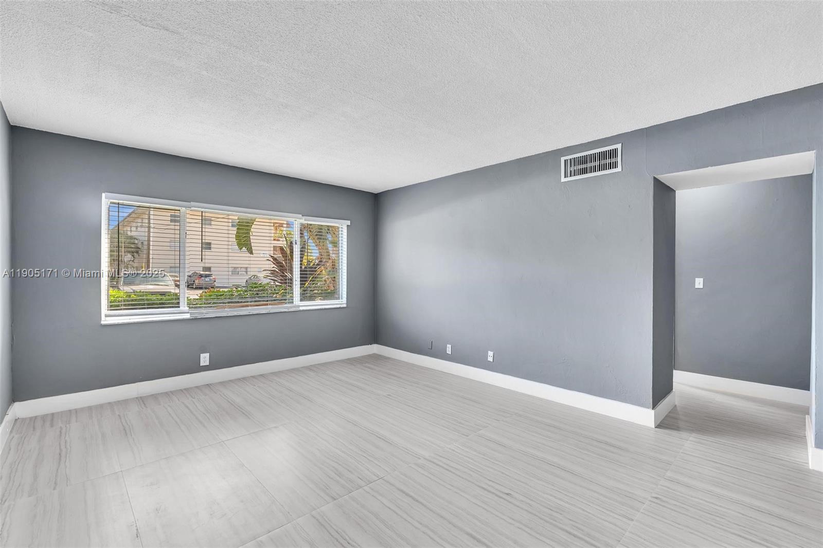 101 Southeast 6th Avenue, Unit 1 Pompano Beach, FL 33060 - Photo 21 of 30 a view of an empty room with wooden floor and a window