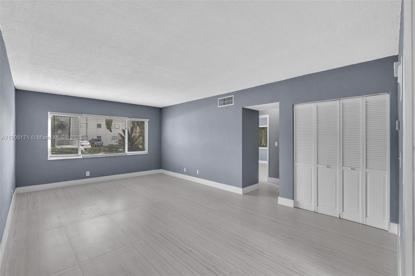 101 Southeast 6th Avenue, Unit 1 Pompano Beach, FL 33060 - Photo 5 of 30 a view of an empty room with wooden floor and window