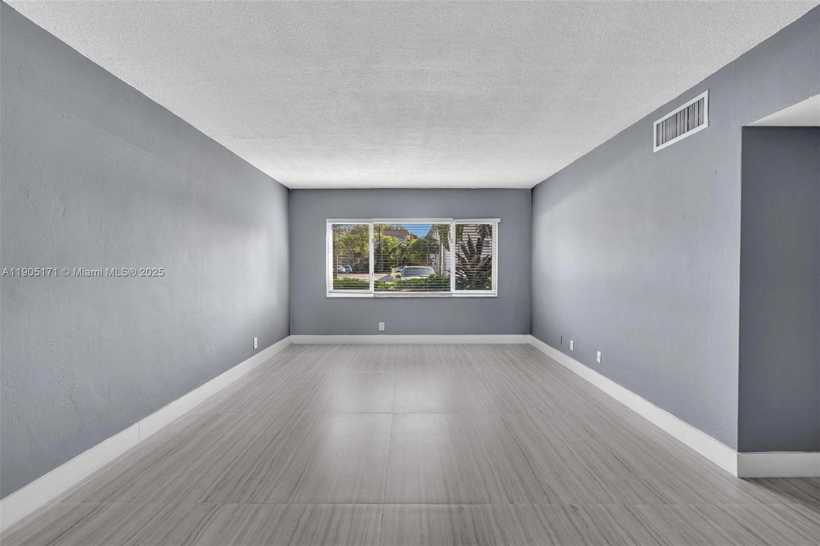 101 Southeast 6th Avenue, Unit 1 Pompano Beach, FL 33060 - Photo 6 of 30 an empty room with wooden floor and windows
