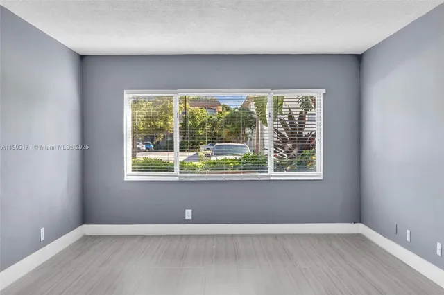 an empty room with wooden floor and a window